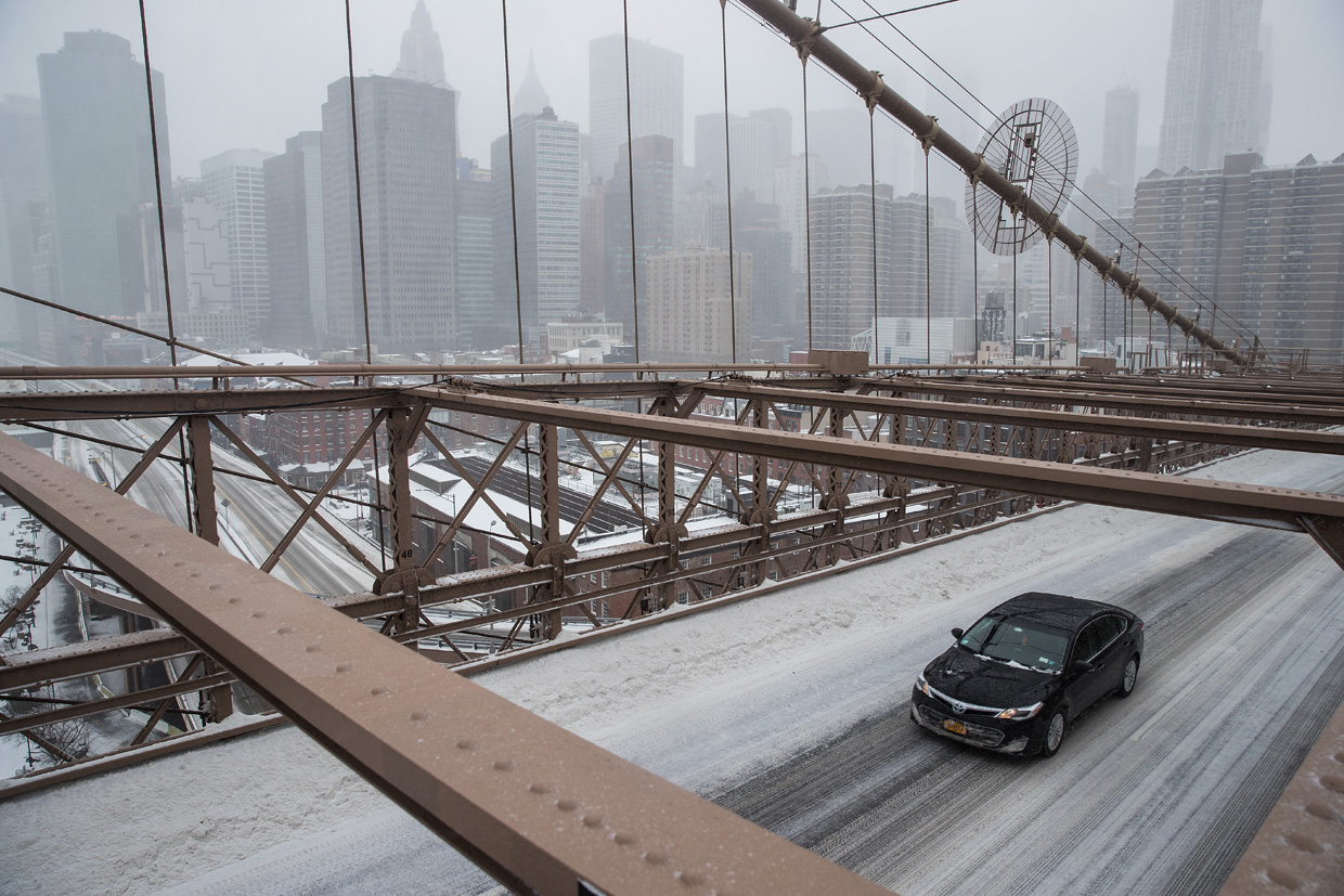 NEW YORK, NY - MARCH 14: A lone vehicle drives through the snow as it crosses the Brooklyn Bridge, March 14, 2017 in New York City. New York City was mostly spared from the winter storm that hit the northeast. (Photo by Drew Angerer/Getty Images)