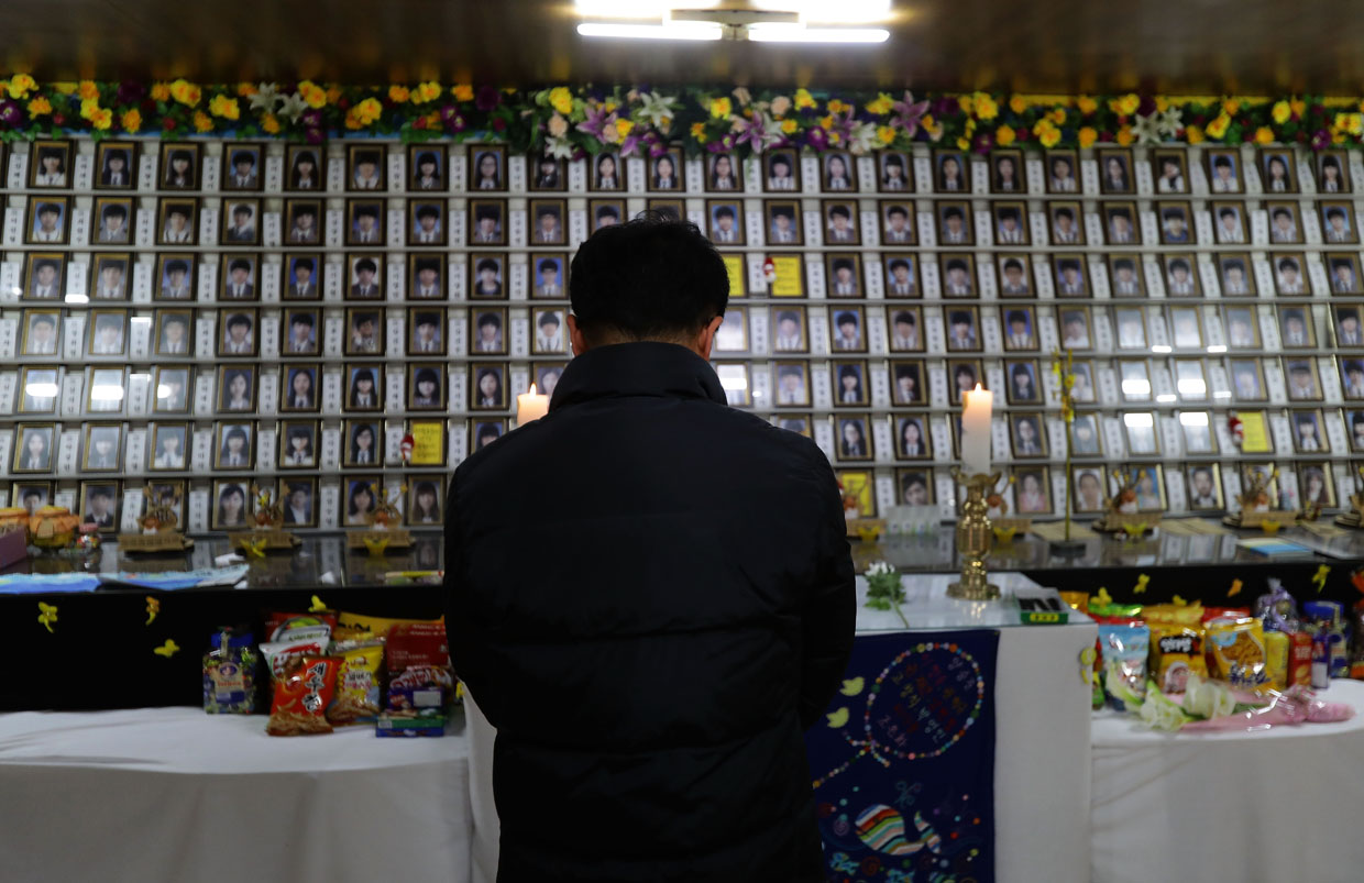 JINDO-GUN, SOUTH KOREA - MARCH 24: A man pays tribute at a group memorial altar for victims of the sunken ferry Sewol on a pier at Paengmok harbour on March 24, 2017 in Jindo-gun, South Korea. The Sewol sank off the Jindo Island in April 2014 leaving more than 300 people dead and nine of them still remain missing. Workers are in the process of an attempt to raise the ferry from the water in the hope that the disasters' final victims will be found. (Photo by Chung Sung-Jun/Getty Images)
