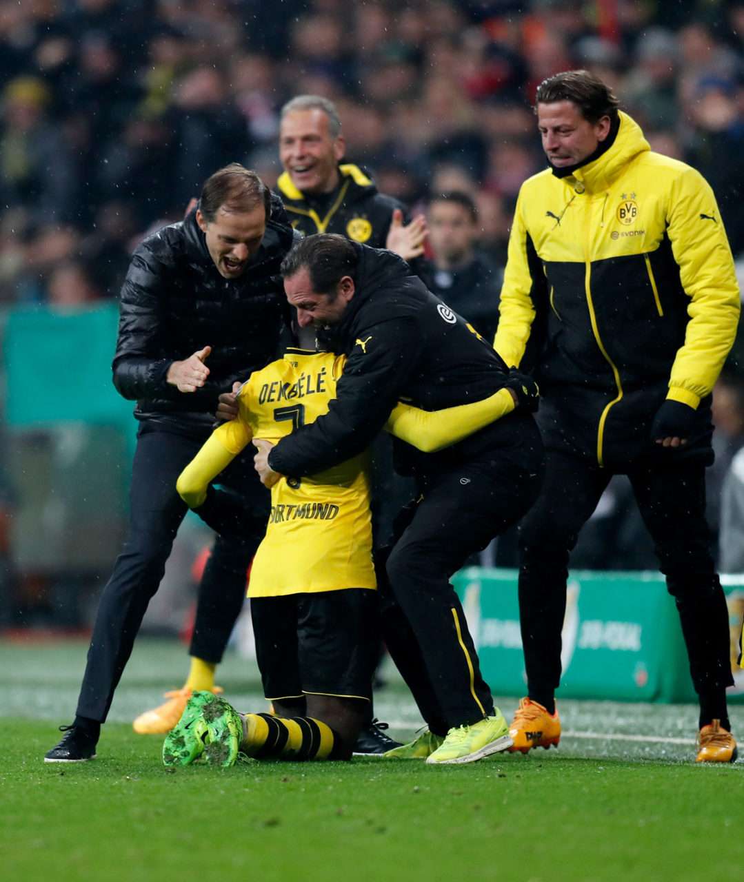 Tiền vệ trẻ Ousmane Dembele số 7 của Dortmund được các thành viên ban huấn luyện đội Dortmund ôm nhau vui mừng sau khi cầu thủ này ghi bàn thắng thứ ba vào lưới Bayern Munich trong trận bán kết giữa hai đội diễn ra trên sân Allianz Arena, Munich, Ðức ngày 26 Tháng Tư 2017. (Hình: Getty Images)