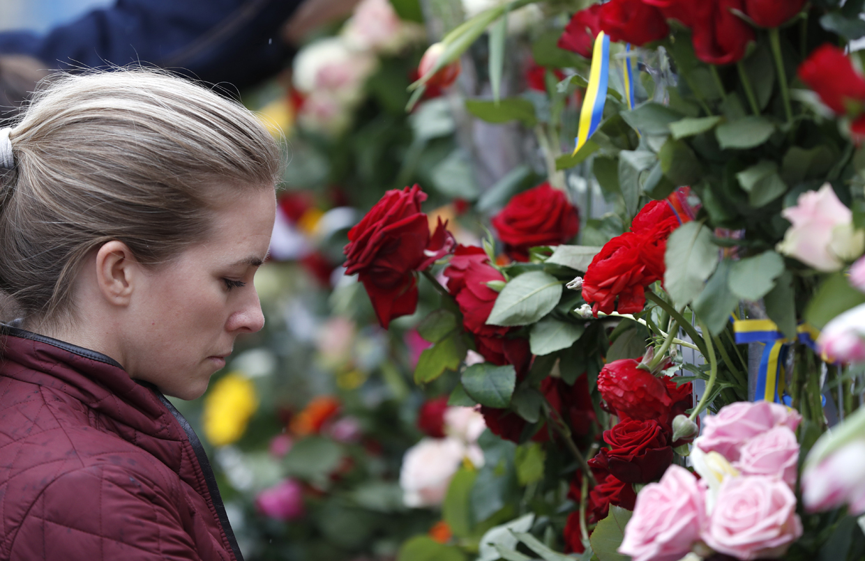 A woman lays flowers at a makeshift memorial near the scene where a truck slammed the day before into a crowd of people outside a busy department store in central Stockholm, on April 8, 2017. / AFP PHOTO / Odd ANDERSEN (Photo credit should read ODD ANDERSEN/AFP/Getty Images)