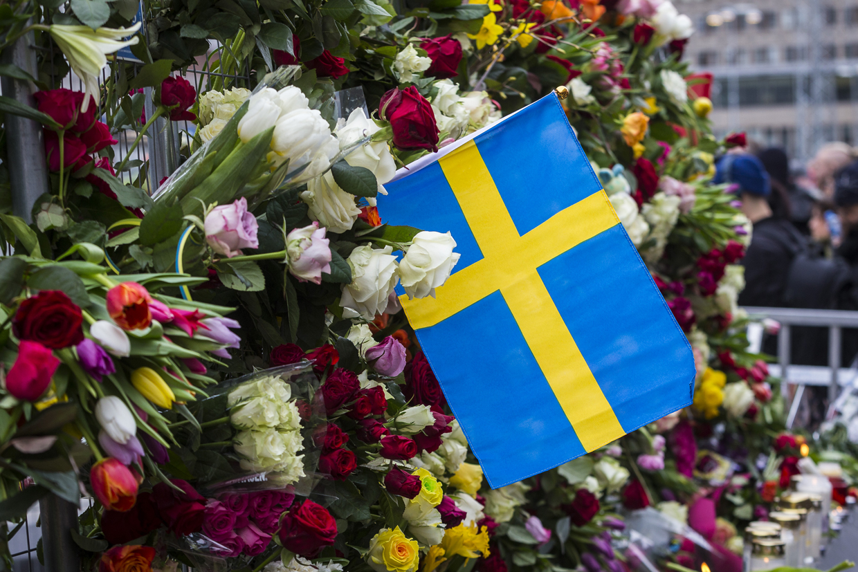 STOCKHOLM, SWEDEN - APRIL 08: Swedish flag placed next to a wall of flowers at the scene of the terrorist truck attack in downtown Stockholm on April 8, 2017 in Stockholm, Sweden. (Photo by Michael Campanella/Getty Images)
