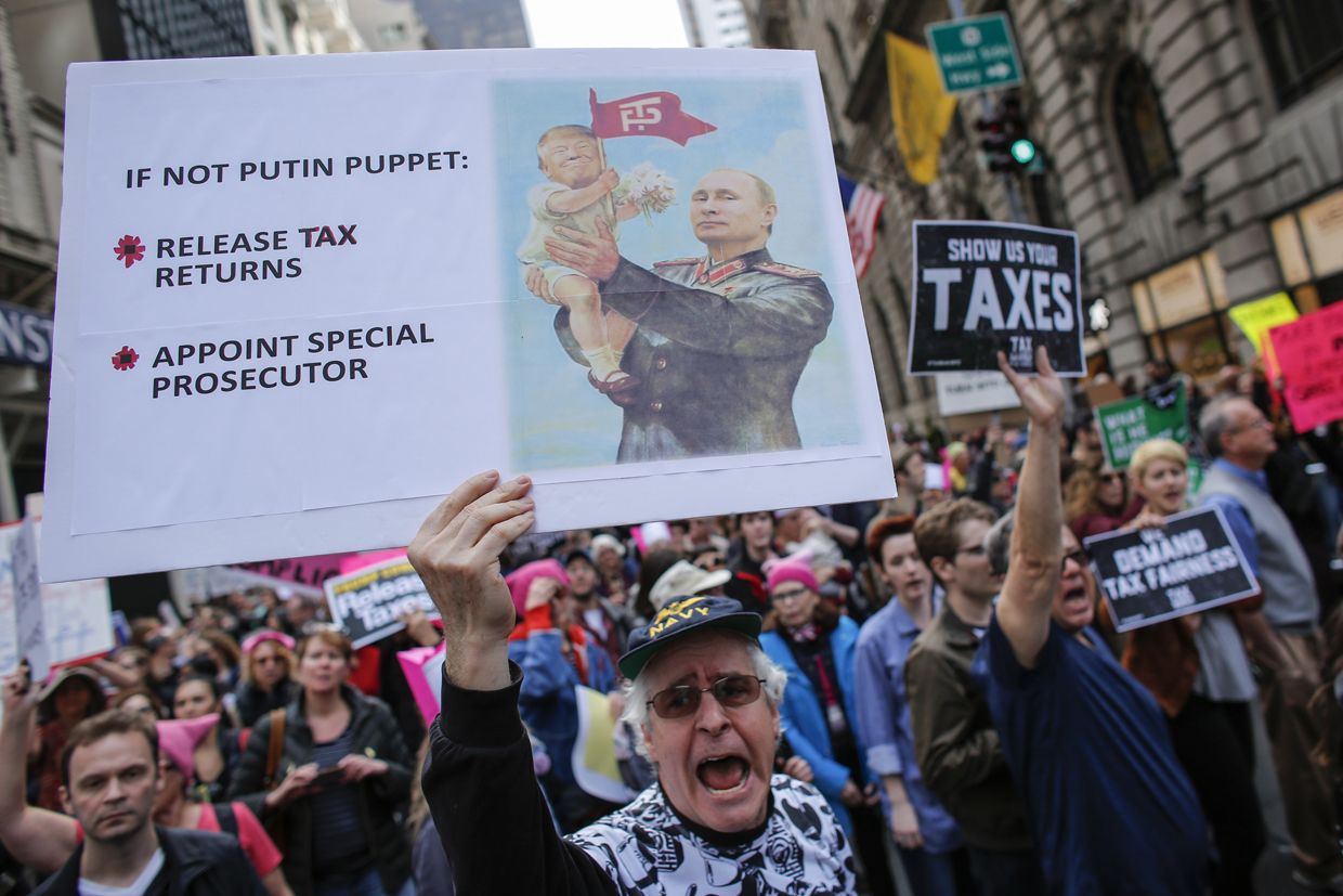 Protestors pass near of Trump Tower during the Nation wide "Tax March" on April 15, 2017 in New York. / AFP PHOTO / KENA BETANCUR (Photo credit should read KENA BETANCUR/AFP/Getty Images)