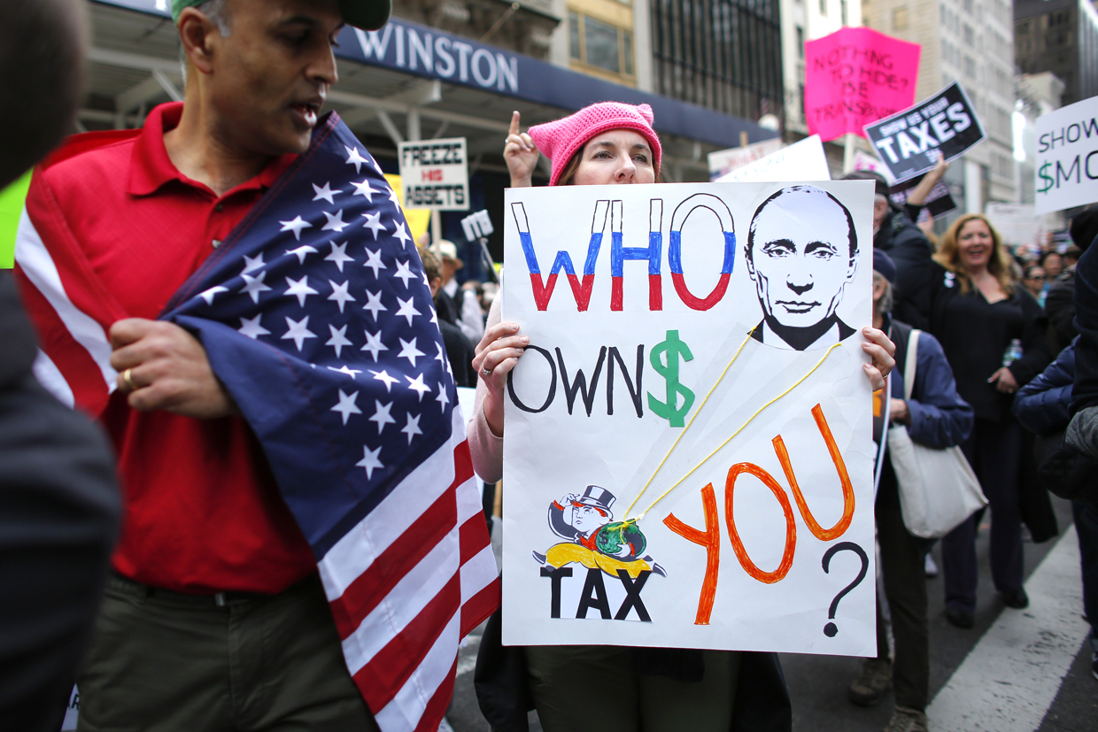 Protestors pass near of Trump Tower during the Nation wide "Tax March" on April 15, 2017 in New York. / AFP PHOTO / KENA BETANCUR (Photo credit should read KENA BETANCUR/AFP/Getty Images)
