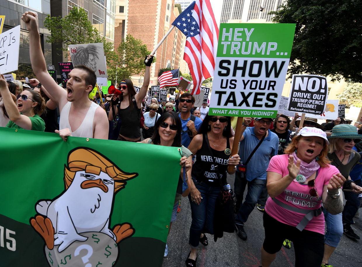 Protestors take part in the "Tax March" to call on US President Donald Trump to release his tax records in Los Angeles, California on April 15, 2017. / AFP PHOTO / Mark RALSTON (Photo credit should read MARK RALSTON/AFP/Getty Images)