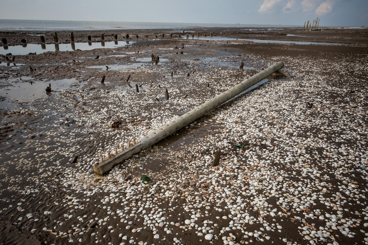 BEN TRE, VIETNAM - APRIL 29: An utility pole destroyed by high tides near the seafront on April 29, 2017 in Bao Thuan Village, Ba Tri District, Ben Tre Province, Vietnam. The Mekong River Delta is amongst the most vulnerable regions in South Vietnam, which is home to more than 17 million people and produces around half of the country's rice harvest with its fertile fields. However, climate change is causing the rise of salt content of water in land that has ben used for rice paddies, coconut groves and other crops, threatening the livelihoods of millions of farmers and fishermen. The Vietnamese government report have stated that 40 percent of the delta could be submerged if sea levels rise by one-meter in decades to come while residents in the low-lying delta have already been affected by more frequent typhoons and heavier floods that could potentially drive hundreds of thousands of people from their homes, according to reports. As many locals have been forced to abandon their rice cultivation due to salinization and risk their livelihood on other ventures such as shrimp farming, reports also state that cycles and storms linked to climate change would not only risk the Mekong Delta, but also up to the coffee crops in the highlands as well as the Red River Delta in the north, affecting large areas near the country's capital, Hanoi. (Photo by Linh Pham/Getty Images)
