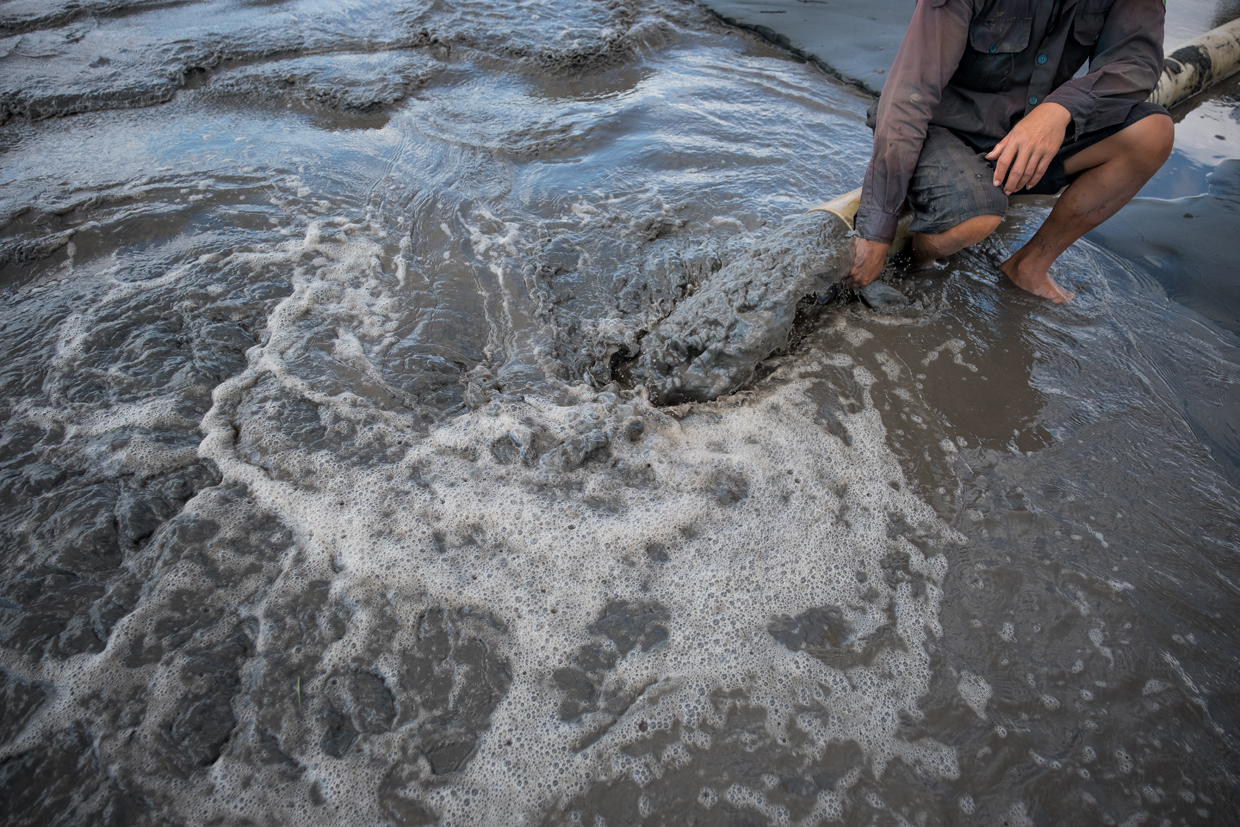 BEN TRE, VIETNAM - APRIL 28: Tran Van Tam, 31, pumps salt water into his piece of land to turn it into a shrimp farm in Thua Duc Village, Binh Dai District, Ben Tre Province, Vietnam. The Mekong River Delta is amongst the most vulnerable regions in South Vietnam, which is home to more than 17 million people and produces around half of the country's rice harvest with its fertile fields. However, climate change is causing the rise of salt content of water in land that has ben used for rice paddies, coconut groves and other crops, threatening the livelihoods of millions of farmers and fishermen. The Vietnamese government report have stated that 40 percent of the delta could be submerged if sea levels rise by one-meter in decades to come while residents in the low-lying delta have already been affected by more frequent typhoons and heavier floods that could potentially drive hundreds of thousands of people from their homes, according to reports. As many locals have been forced to abandon their rice cultivation due to salinization and risk their livelihood on other ventures such as shrimp farming, reports also state that cycles and storms linked to climate change would not only risk the Mekong Delta, but also up to the coffee crops in the highlands as well as the Red River Delta in the north, affecting large areas near the country's capital, Hanoi. (Photo by Linh Pham/Getty Images)