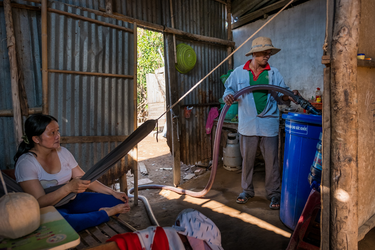 BEN TRE, VIETNAM - APRIL 28: Nguyen Thanh Nhat, 39, a water truck driver, pumps fresh water from his truck to client's storages on April 28, 2017 in Thua Duc Village, Binh Dai District, Ben Tre Province, Vietnam. Due to the lack of fresh water caused by salinization, people in Thu Duc Village need to buy fresh water from water truck from VND100,000 to VND200,000 (around US$4.5 to US$9) for 3 cubic meters. The Mekong River Delta is amongst the most vulnerable regions in South Vietnam, which is home to more than 17 million people and produces around half of the country's rice harvest with its fertile fields. However, climate change is causing the rise of salt content of water in land that has ben used for rice paddies, coconut groves and other crops, threatening the livelihoods of millions of farmers and fishermen. The Vietnamese government report have stated that 40 percent of the delta could be submerged if sea levels rise by one-meter in decades to come while residents in the low-lying delta have already been affected by more frequent typhoons and heavier floods that could potentially drive hundreds of thousands of people from their homes, according to reports. As many locals have been forced to abandon their rice cultivation due to salinization and risk their livelihood on other ventures such as shrimp farming, reports also state that cycles and storms linked to climate change would not only risk the Mekong Delta, but also up to the coffee crops in the highlands as well as the Red River Delta in the north, affecting large areas near the country's capital, Hanoi. (Photo by Linh Pham/Getty Images)