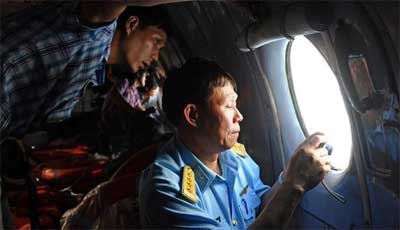 This picture taken from aboard a Soviet-made AN-26 used by Vietnamese Air Force to look for missing Malaysia Airlines flight MH370, shows an officer (R) and a reporter during search operations over the southern seas off Vietnam on March 9, 2014 Photo by Hoang Dinh Nam, AFP